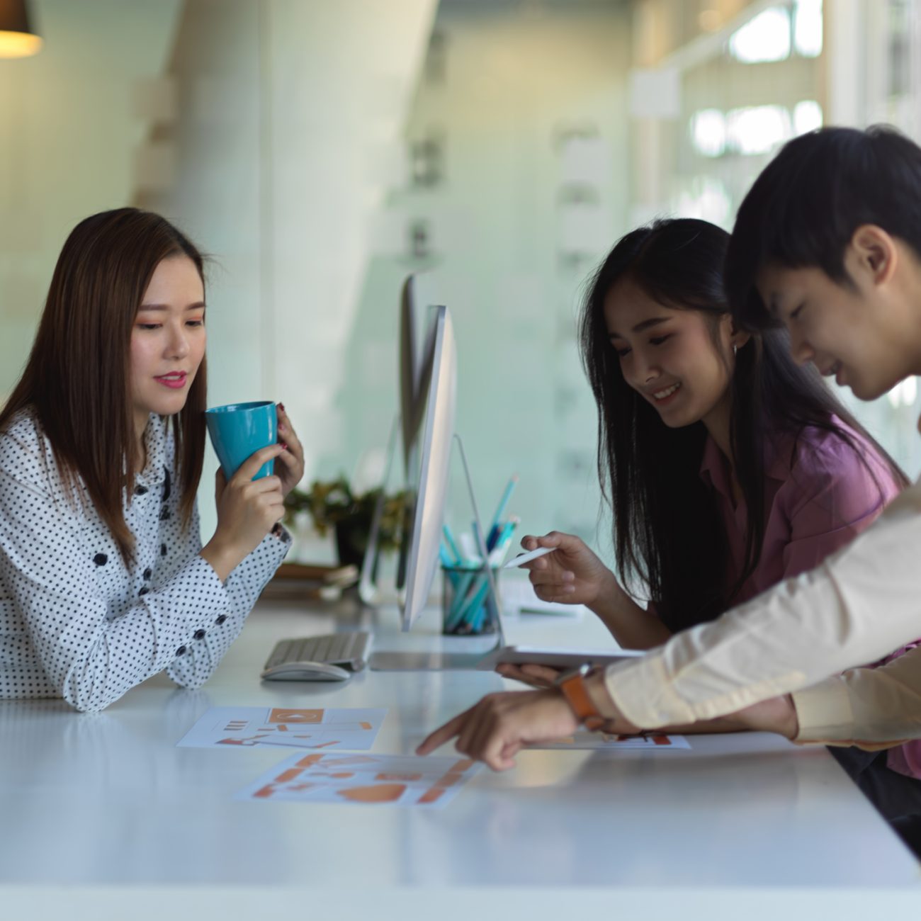 Portraits of UI developer team meeting on their project with tablet and paperwork in office room